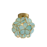 "A close-up view of a floral ceiling light with a brass frame and light blue glass petals, showcasing its intricate design."
