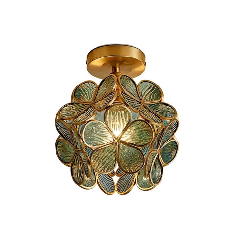 "A green floral ceiling light with a brass frame and textured glass petals, adding a touch of nature-inspired elegance to a room."