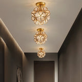 "A series of modern, floral ceiling lights with brass frames and textured glass petals, illuminating a contemporary hallway."