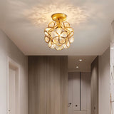 "A single, floral-inspired ceiling light with a brass frame and luminous glass petals, illuminating a modern hallway."