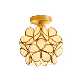 "A modern, floral-inspired ceiling light with a brass frame and luminous, ivory glass petals, providing a soft, elegant glow."