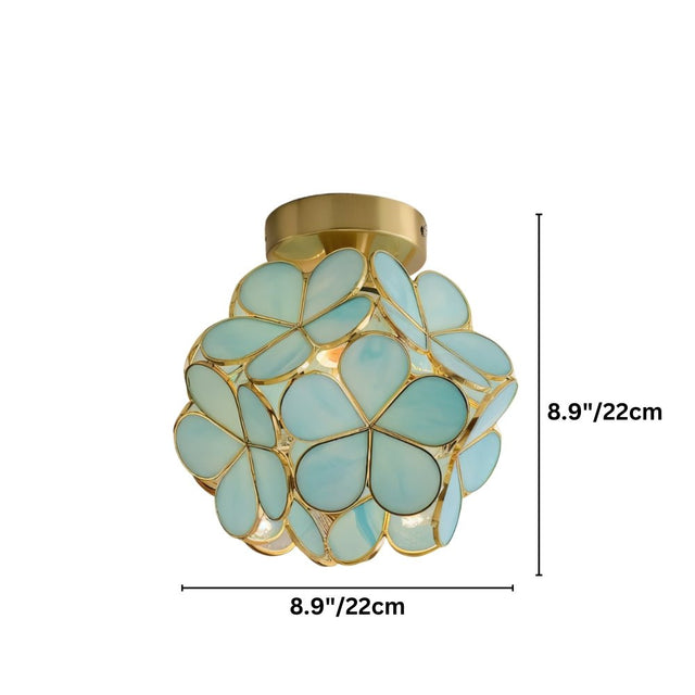 "A floral-inspired ceiling light with a brass frame and delicate, light blue glass petals, emitting a warm glow."