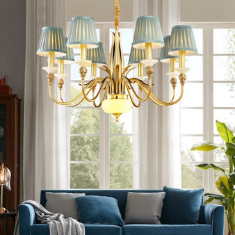 "A gold chandelier with blue fabric shades hanging in a living room."