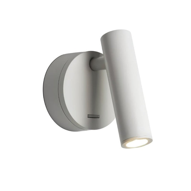 "A white aluminum wall lamp with an adjustable cylindrical head, shown lit up against a white background."