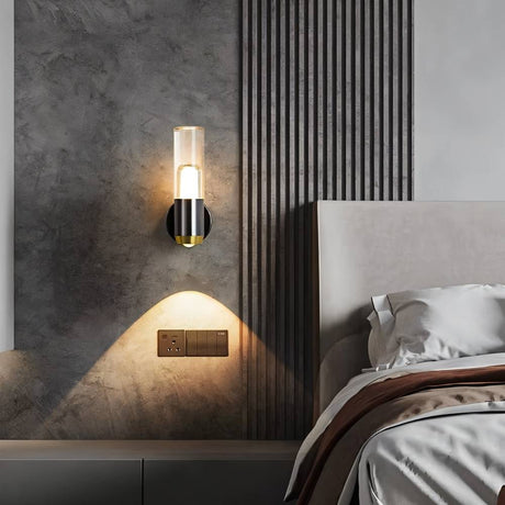 "Modern cylindrical wall lamp with a metal base and acrylic diffuser providing accent lighting in a contemporary bedroom."