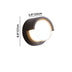 Black circular outdoor wall lamp with frosted white diffuser and warm brass accent, 6.6"H x 3.9"W.