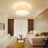 "Contemporary living room with a minimalist fabric drum ceiling light providing ambient lighting."