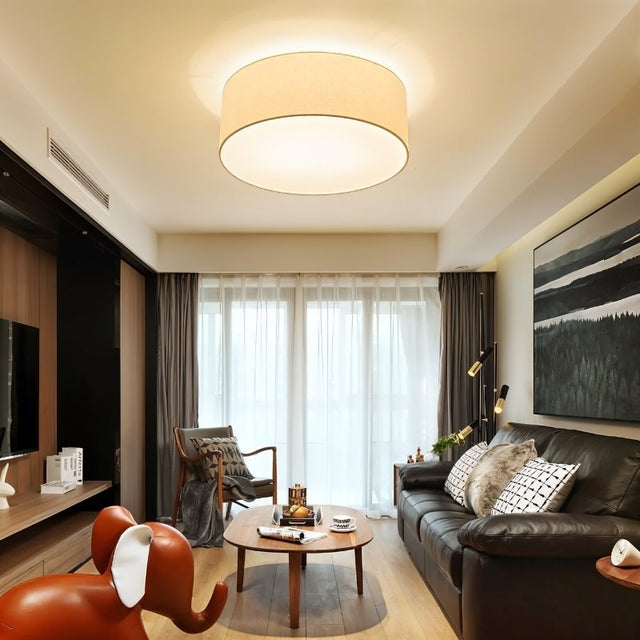 "Modern living room interior with a minimalist fabric drum ceiling light illuminating the space."