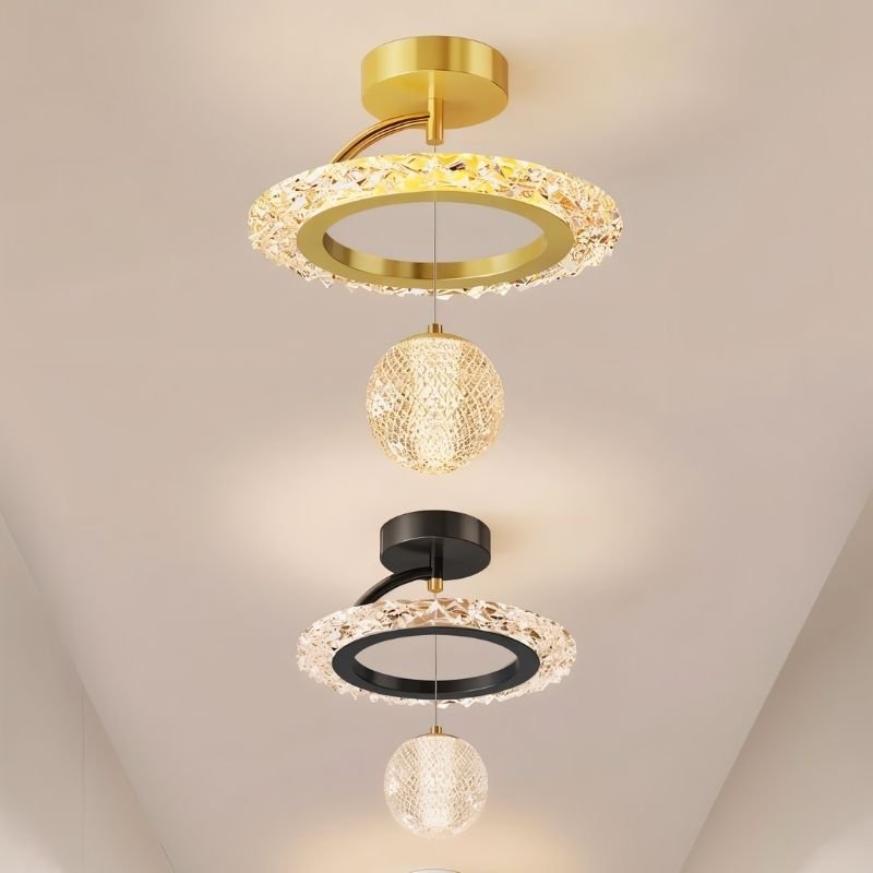 "Multiple ceiling lights with circular frames and hanging crystal spheres in gold, black, and white, shown against a blurred background."