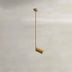 Brass cylinder pendant light with adjustable rod hanging from white ceiling.