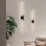 "Pair of modern acrylic wall sconce lights with a minimalist design on a light-colored wall."