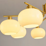 "A close-up view of a chandelier with multiple opal glass globes and a gold metal frame."