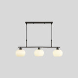 "A 3-light linear chandelier with opal glass globes, against a light gray background."