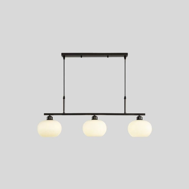 "A 3-light linear chandelier with opal glass globes, against a light gray background."