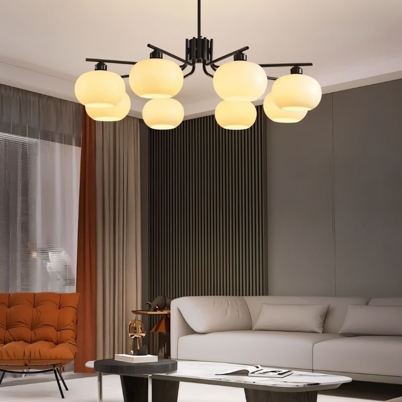 "An 8-light round chandelier with opal glass globes and a black metal frame, hanging in a modern living room with a couch and decor."