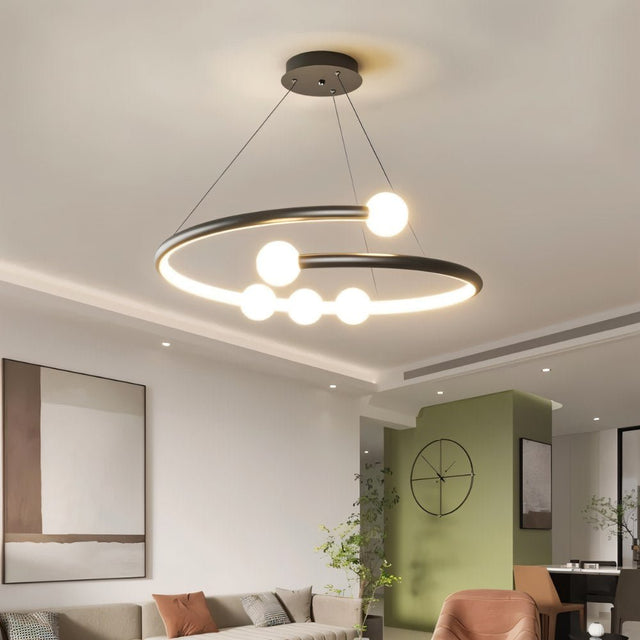 "Modern chandelier with a circular design and minimalist bulb holders illuminating a contemporary living room."