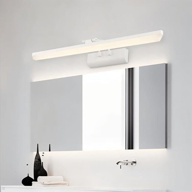 "A white LED vanity light mounted above a modern bathroom mirror with a white countertop and decorative objects."