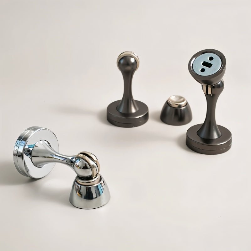 "Group of sleek, zinc-alloy magnetic door stops with contoured designs in various styles and finishes, designed to prevent door slams and wall damage in modern interiors."
