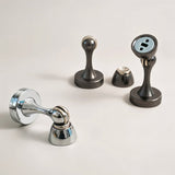 "Group of sleek, zinc-alloy magnetic door stops with contoured designs in various styles and finishes, designed to prevent door slams and wall damage in modern interiors."