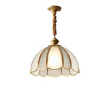 "A vintage-style pendant light with a scalloped glass shade and copper trim, hanging by a twisted rope."