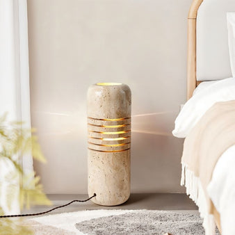 "Natural travertine floor lamp providing soft ambient lighting in a bedroom"