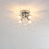 Modern chrome ceiling light with radiating crystal branches and integrated LED bulbs against a white ceiling.