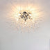 Modern burst ceiling light fixture with clear glass rods and gold finish against white ceiling.
