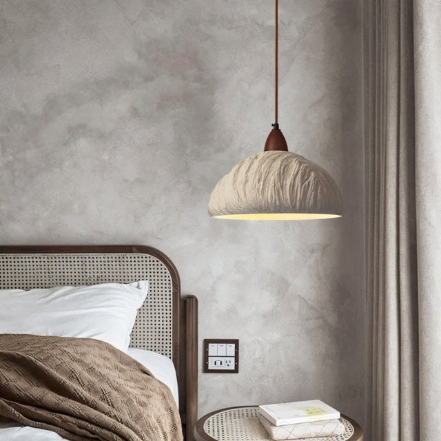 "Wabi Sabi cement pendant light with raw textures and refined imperfections, creating a warm and inviting atmosphere in a contemporary bedroom."