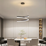 "Modern pendant light with a spiral ribbon design over a dining table in a contemporary dining room with built-in shelving."