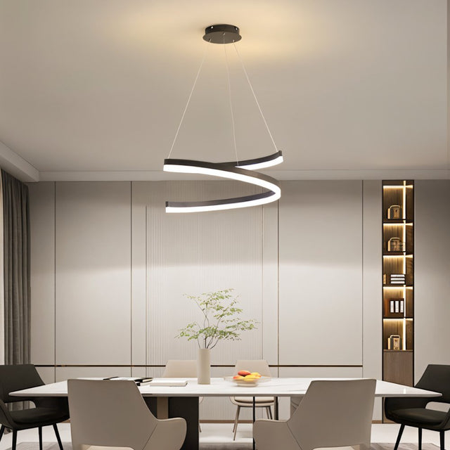 "Modern pendant light with a spiral ribbon design over a dining table in a contemporary dining room with built-in shelving."