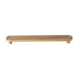 "Brass Art Deco handle with rounded edges and parallel lines."