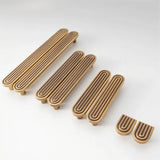 "Set of brass Art Deco knobs and pulls with rounded edges and parallel lines."