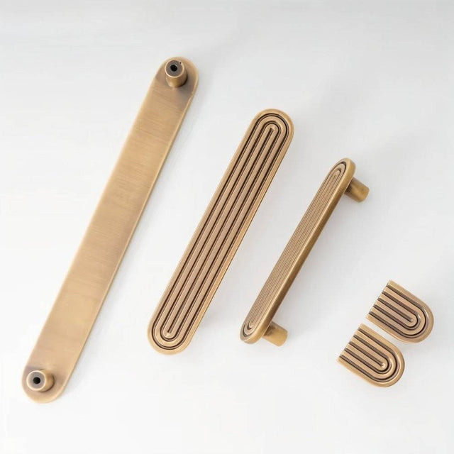 "Set of brass Art Deco cabinet hardware with rounded edges and parallel lines."