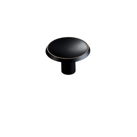 "Black brass circular knob with gold trim, isolated on a white background."