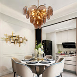 "A modern chandelier with layered smoked glass discs hanging above a round dining table in a contemporary dining area."