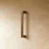 Pair of bronze pull handles on navy blue paneled cabinet doors, front view studio shot