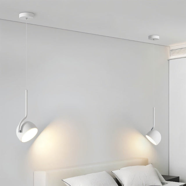 "Two minimalist white pendant lights with curved iron fixtures and dome-shaped shades hang above a modern bed with white linens."