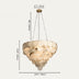 Cream alabaster chandelier with brass fixture suspended by chains against a neutral background.