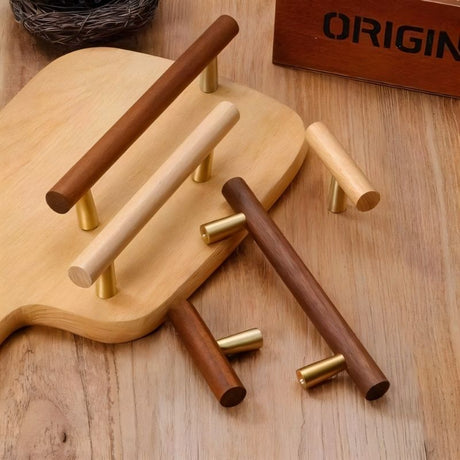 "Modern wooden drawer knobs with brass accents on a wooden cutting board."