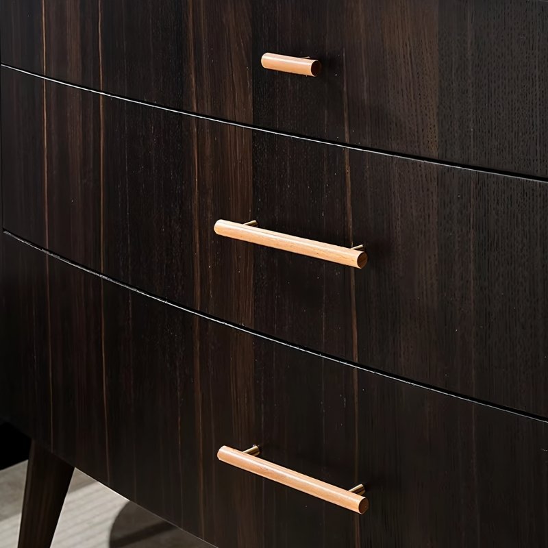 "Close-up of modern wooden drawer pulls with brass accents on a dark wood dresser."