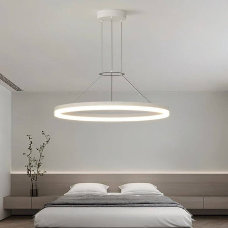"A modern white ring chandelier in a bedroom with a minimalist design."
