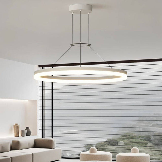 "A modern white ring chandelier in a living room with a large window and seating area."