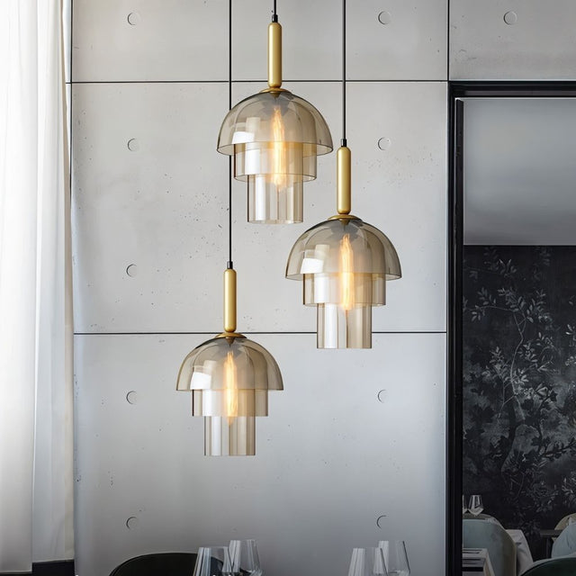   "Three modern pendant lights with layered smoked glass shades and metallic accents over a dining table in a contemporary dining room."
