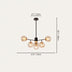 Black metal chandelier with five amber glass globe shades on white background.