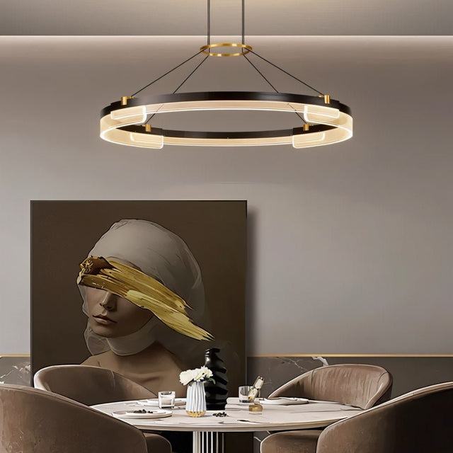 "Black and gold Capli chandelier with dual aluminum rings and acrylic diffusers, hanging above a dining table with a modern painting."