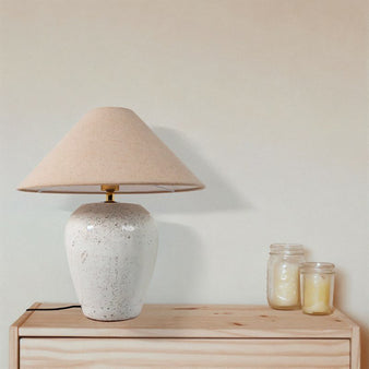 "Casewell table lamp with a beige shade on a wooden nightstand in a bedroom."