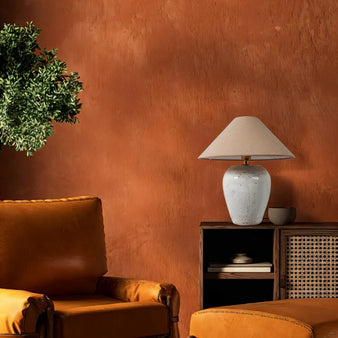 "Casewell table lamp illuminating a cozy living room corner with warm, textured walls."