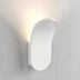 "Close-up of a modern wall lamp made from gypsum and aluminum, showcasing an elegant organic design that casts soft upward light, ideal for contemporary interior spaces."