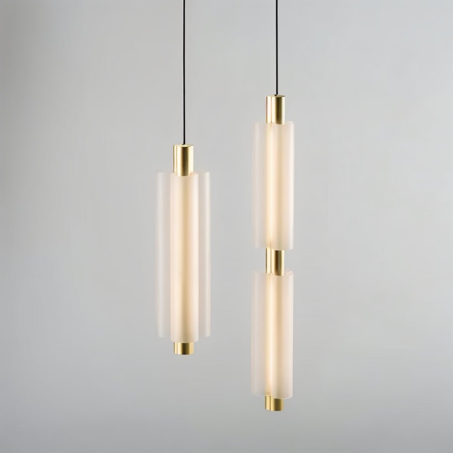 "Two minimalist pendant lights, one single-tiered and one double-tiered, with frosted acrylic cylinders and brass accents."