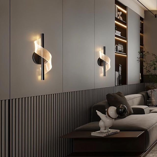"Pair of modern sculptural wall lamps with spiral acrylic diffusers flanking a wall in a contemporary living room, providing soft, ambient lighting."